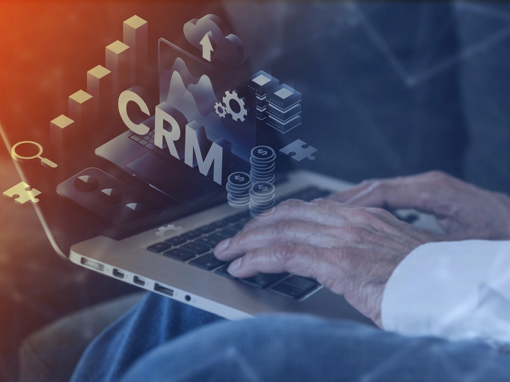 hands typing on laptop with crm software graphics – custom software development company in kerala